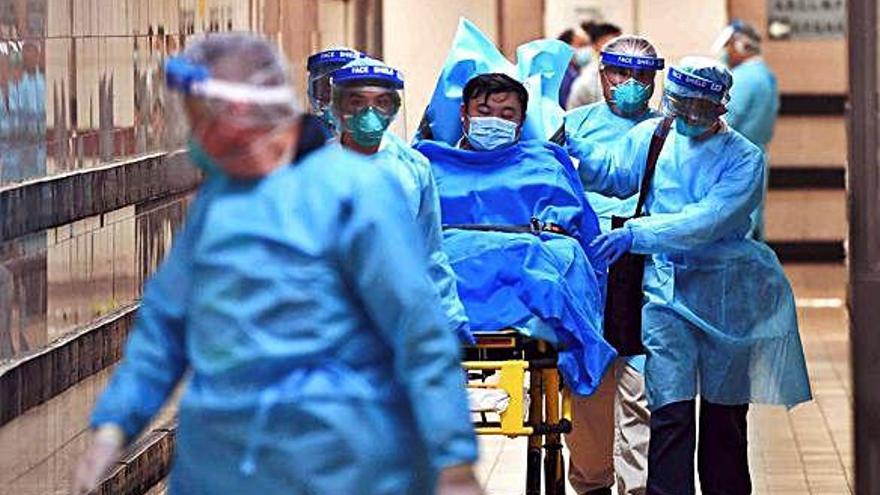 Personal d&#039;un hospital de Honk Kong porta amb llitera un pacient que podria estar infectat pel virus