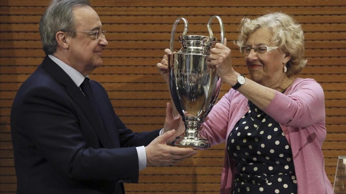 Florentino Pérez le entrega a Manuel Carmena, alcaldesa de Madrid, una réplica de la Champions