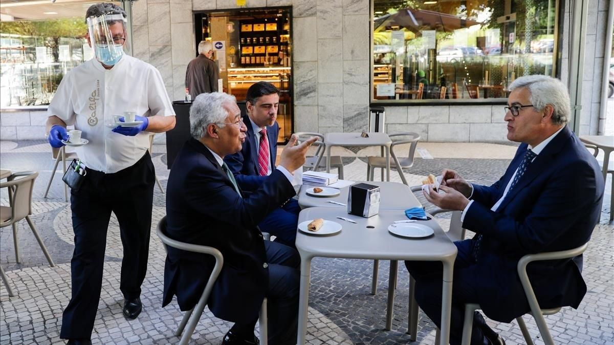 El primer ministro de Portugal, Antonio Costa, intercambia puntos de vista con el presidente del consejo parroquial Antonio Cardoso y con el subsecretario de Estado del primer ministro Tiago Antunes, durante el desayuno en .Lisboa