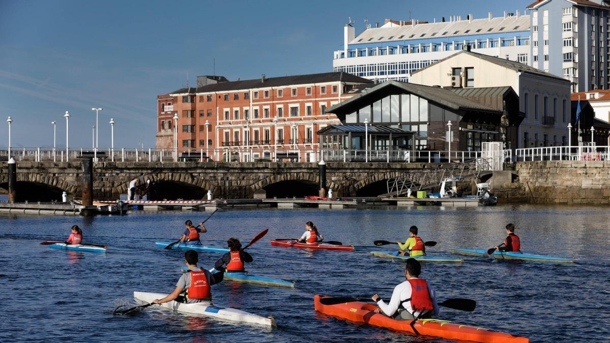 Jóvenes piragüistas del Grupo Covadonga remando en el muelle, en otoño.