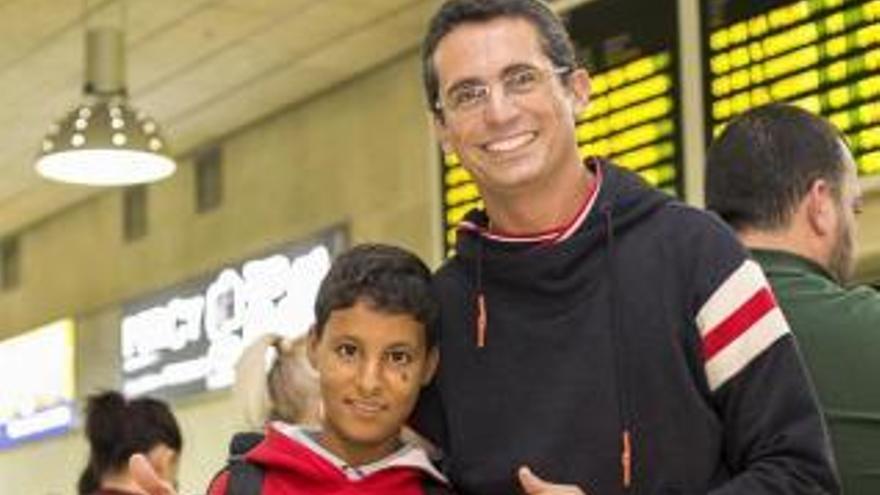 Ramón Estévez y su niño saharaui de acogida, Salek, ayer en el aeropuerto.