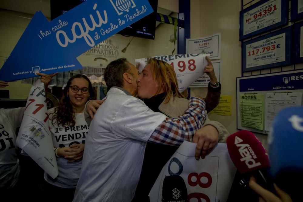 Neringa, la mujer a la que le ha tocado el Gordo en Benetússer, celebra el premio con el dueño de la administración de lotería.