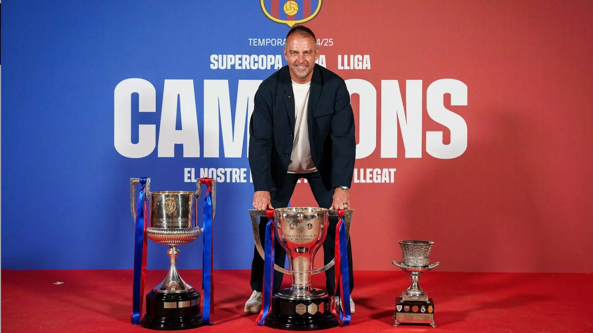 Hansi Flick with Barcelona trophies