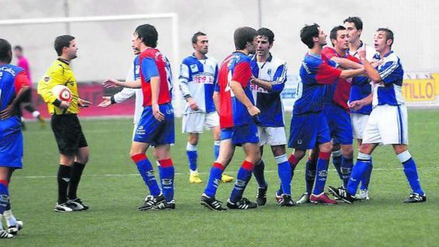 Una disputa entre jugadores de ambos equipos en el partido de ida entre Langreo y Tuilla en Nuevo Ganzábal.