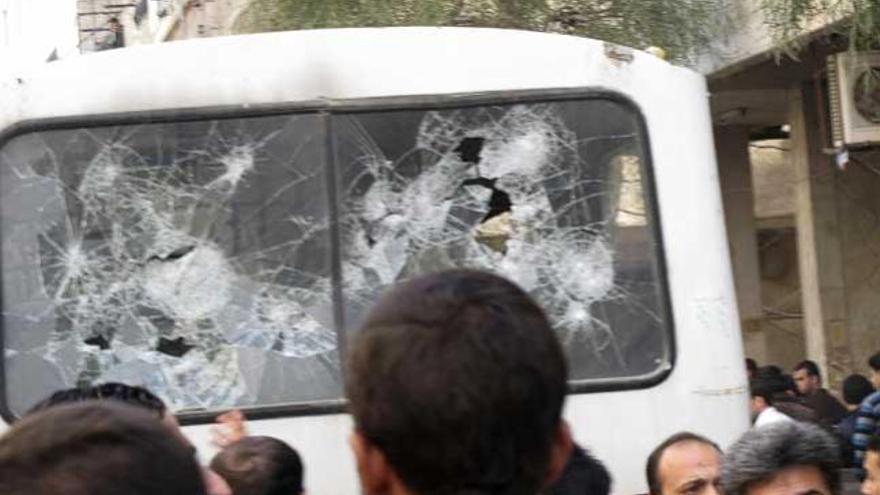 Un autobús con los cristales rotos en el barrio Mouadamieh de Damasco, escenario de nuevas protestas.