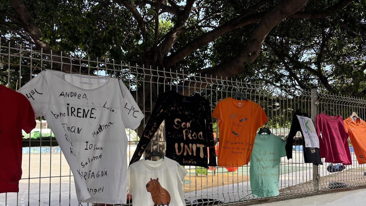 Las familias cuelgan camisetas en las vallas del CEIP Son Pisà en protesta contra la reincorporación de Miquel Roldán