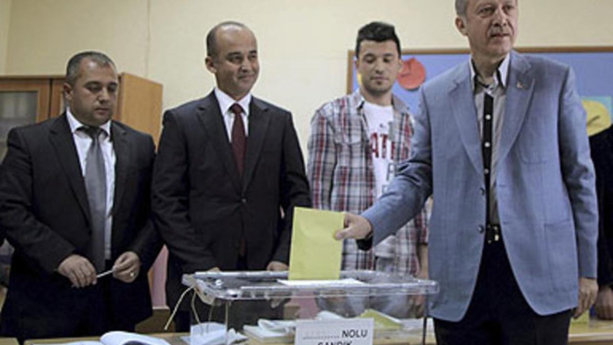 El primer ministro turco, Recep Tayyip Erdogan (derecha), ejerce su derecho al voto en un centro electoral en Estambul.