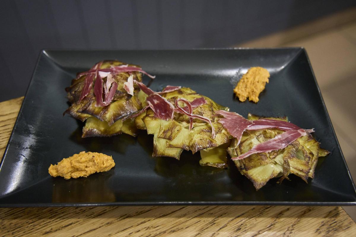 Carxofes a la brasa amb pernil ibèric i romesco, un dels plats nous de Cn Ginesta.