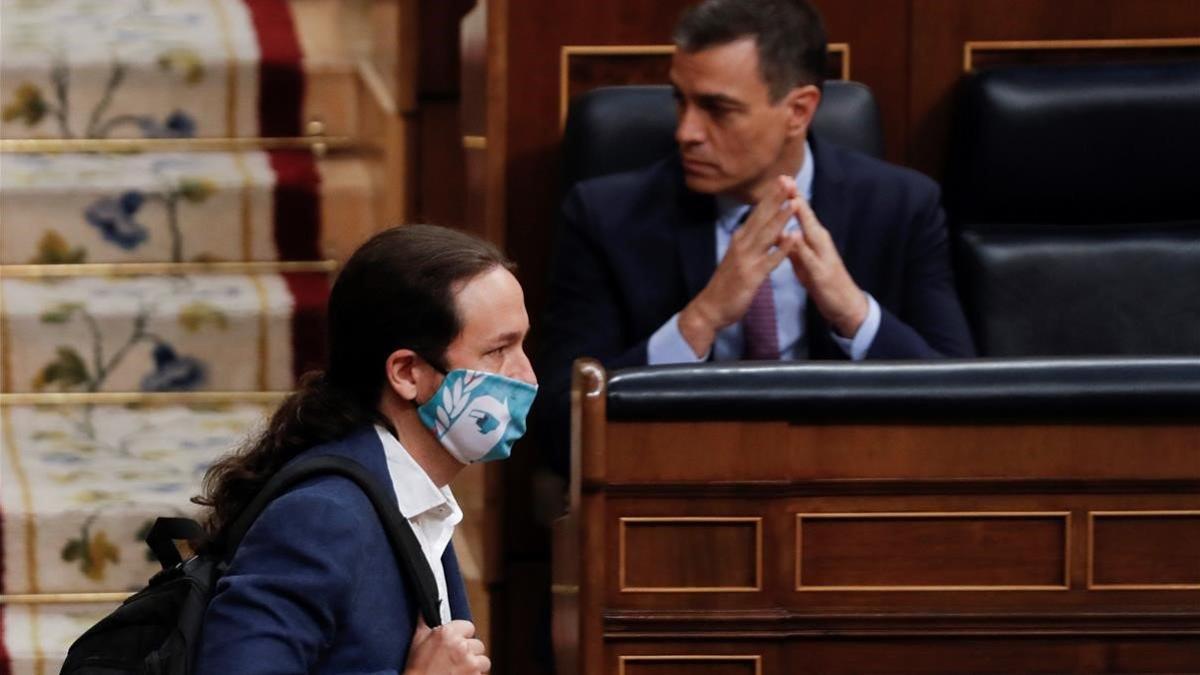 El vicepresidente Pablo Iglesias, pasa delante del jefe del Gobierno, Pedro Sánchez, este miércoles, en el hemiciclo del Congreso de los Diputados.