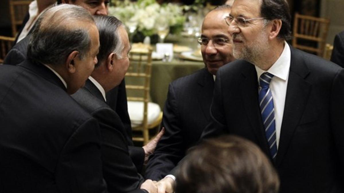 Rajoy saluda al magnate mexicano Carlos Slim (izquierda) ante la mirada del presidente de México, Felipe Calderón (segundo por la derecha), durante una cena en honor del presidente español, el miércoles.