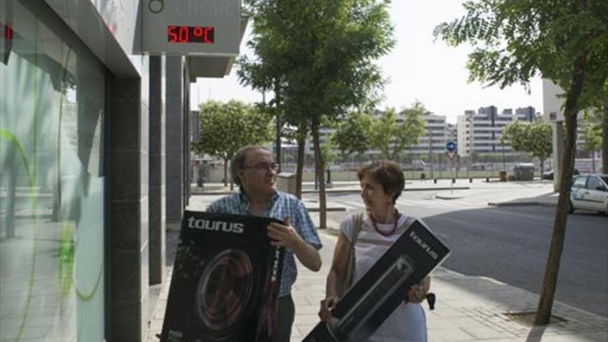 Unos vecinos de Lleida, tras comprar un ventilador, ayer.
