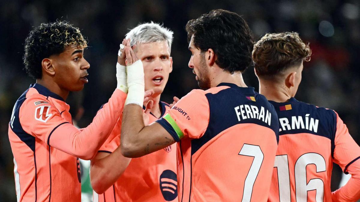 Els jugadors del Barça feliciten Ferran Torres després de marcar ahir al Martínez Valero. | JOSÉ JORDÁN / AFP
