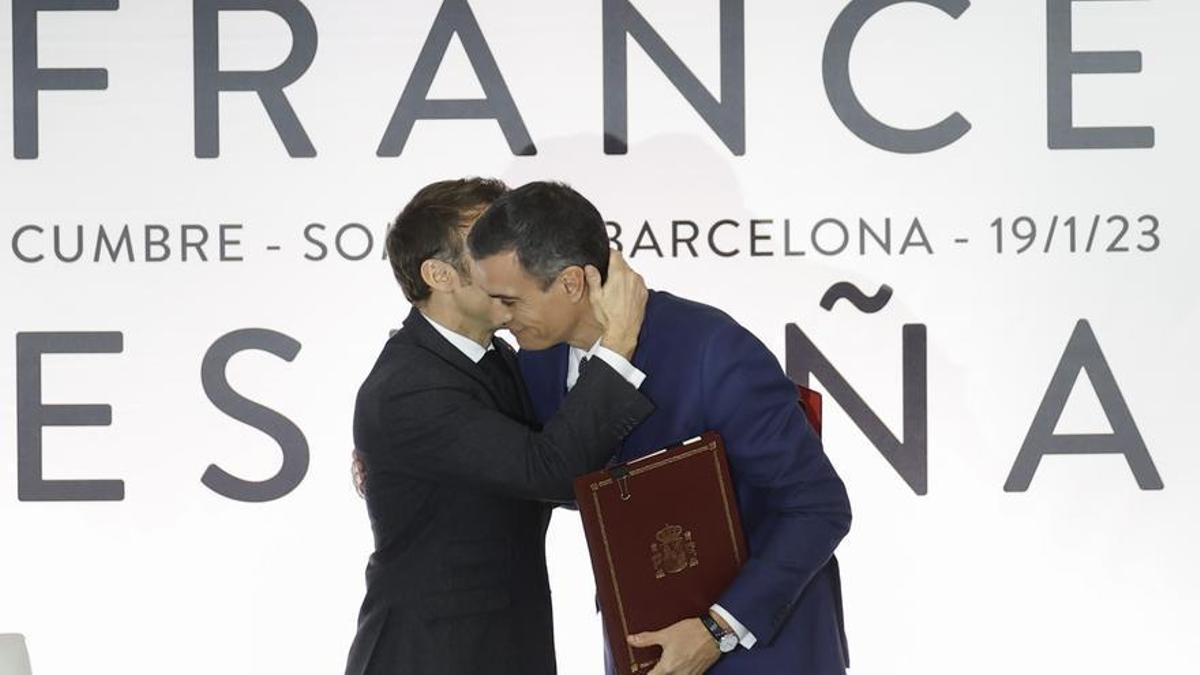 El presidente del Gobierno, Pedro Sánchez (c-d), abraza al presidente francés, Emmanuel Macron, durante la ceremonia de firma de acuerdos celebrada en el marco de la Cumbre Hispanofrancesa, este jueves, en Barcelona.