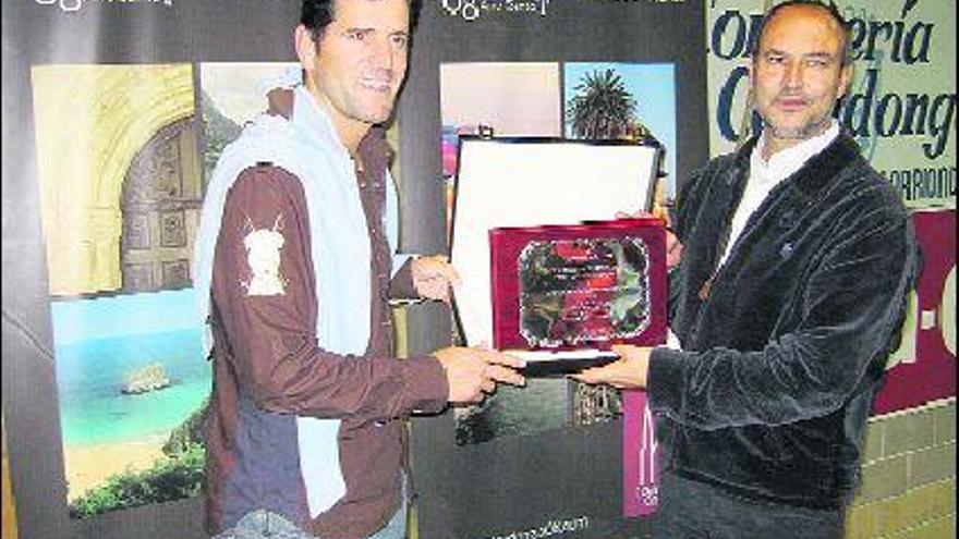 Abraham Olano, recogiendo una placa de manos de Jaime García, presidente de Incatur, ayer, en Cangas de Onís.