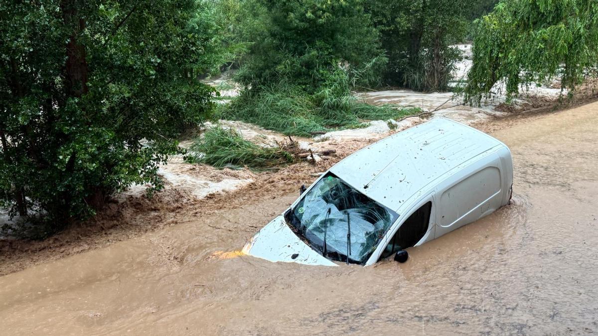 Una furgoneta embarrancada por la crecida de un río durante un temporal pasado en Catalunya.