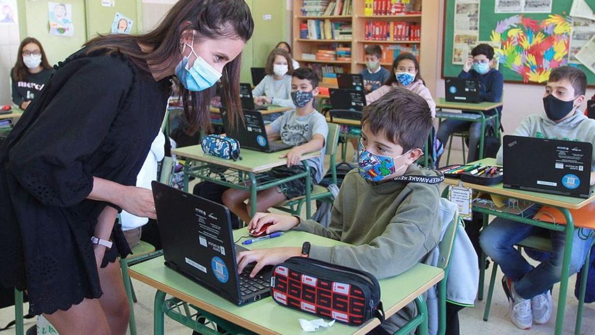 Una profesora y alumnos con mascarillas en un colegio de Ourense.