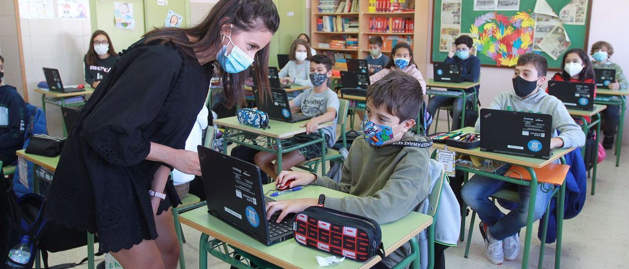 Una profesora y alumnos con mascarillas en un colegio de Ourense.