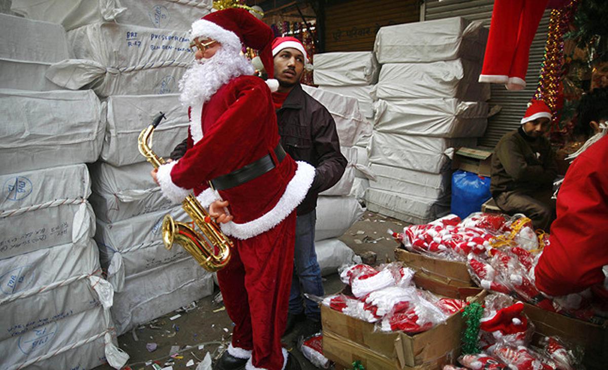 Un venedor arregla la roba d’una figura de Santa Claus en un mercat de Nova Delhi (Índia).