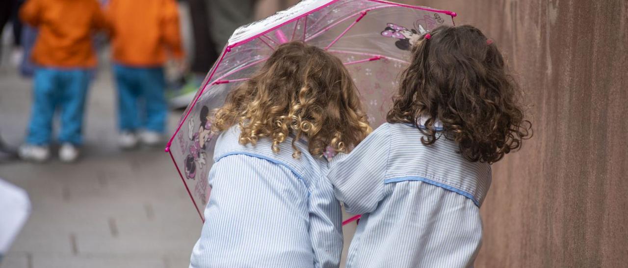 Dos niñas se protegen con un paraguas de la lluvia junto a un colegio coruñés. |   // CASTELEIRO/ROLLER AGENCIA