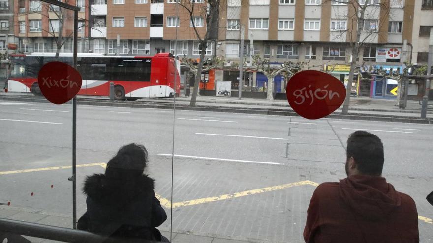 Pasajeros en una marquesina de Emtusa junto a la Gota de Leche, en la calle Palacio Valdés.