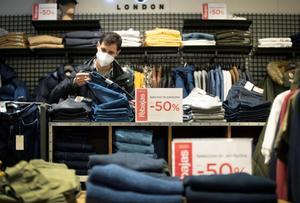 Un joven se interesa por las prendas en rebajas del departamento de moda joven en un centro comercial de Pamplona, en una fotografía de archivo. EFE/ Villar López