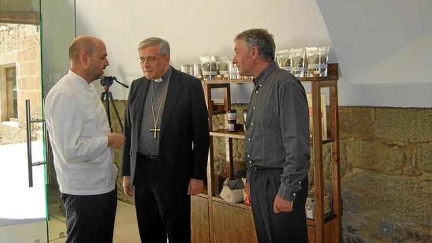 El xef Manel Casanovas, l&#039;abat Josep Soler i el superior Xavier Poch conversen a la botiga del Miracle