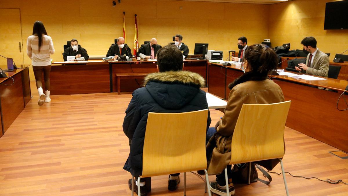 L'acusat i la seva intèrpret, d'esquenes, durant el judici que s'ha celebrat aquest dijous a la Secció Tercera de l'Audiència de Girona