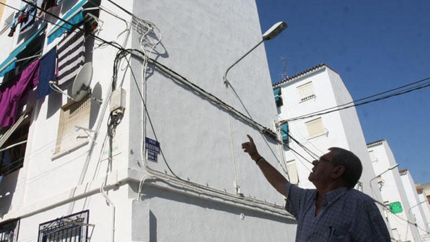 José Pérez, delante de un bloque del barrio que da a la avenida de Velázquez, con las grapas para el nuevo cableado