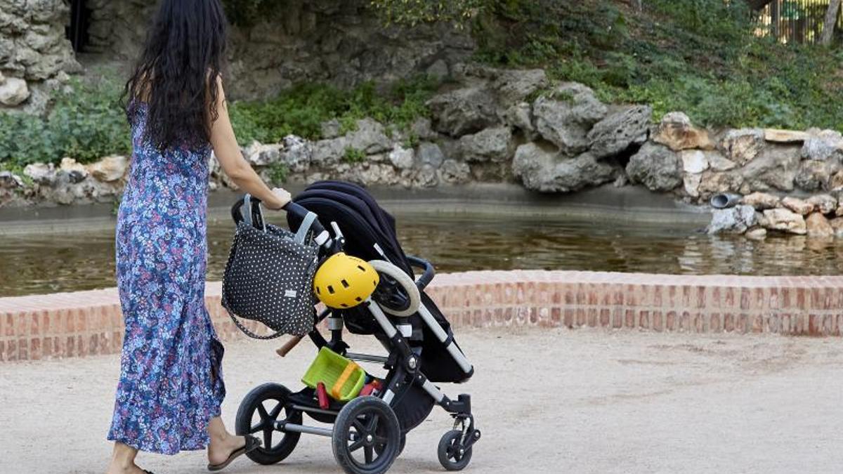 Una mujer pasea con un carrito de bebé