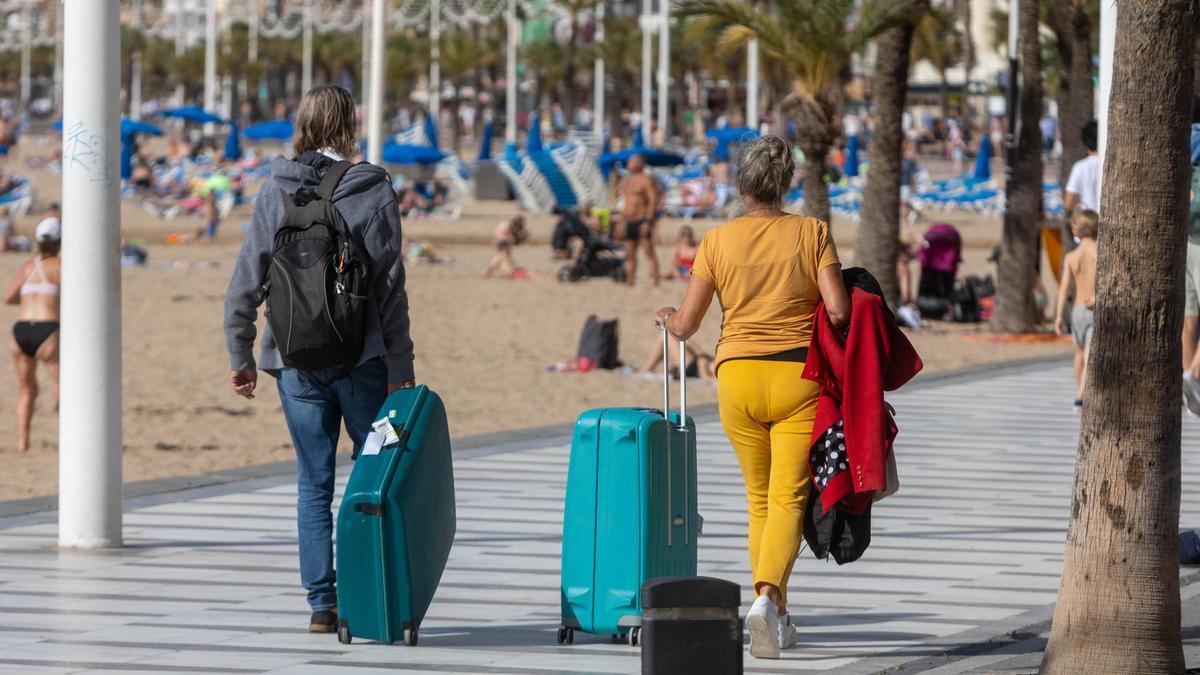 Dos viajeros con sus maletas en Benidorm.