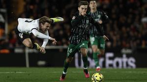 Febas conduce el balón durante el Valencia-Elche, ante el salto de un rival