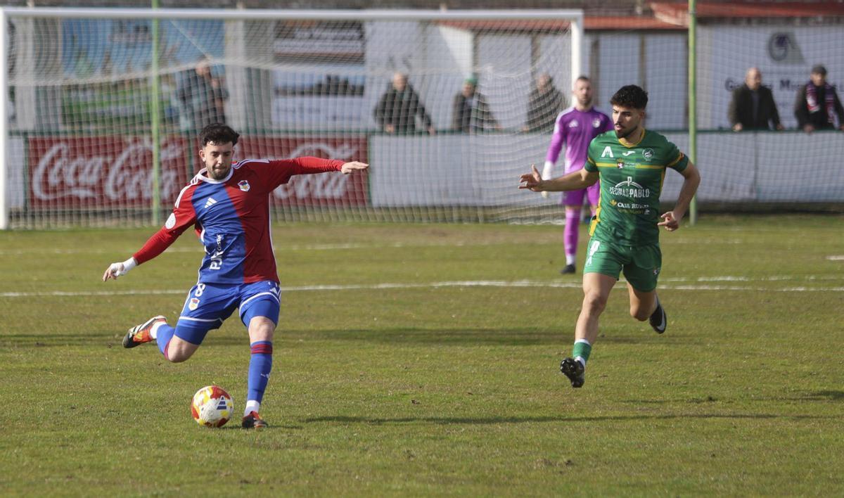 Sergio Orviz se dispone a golpear el balón, con el jugador del Atlético Astorga Ayoub observándole.  |