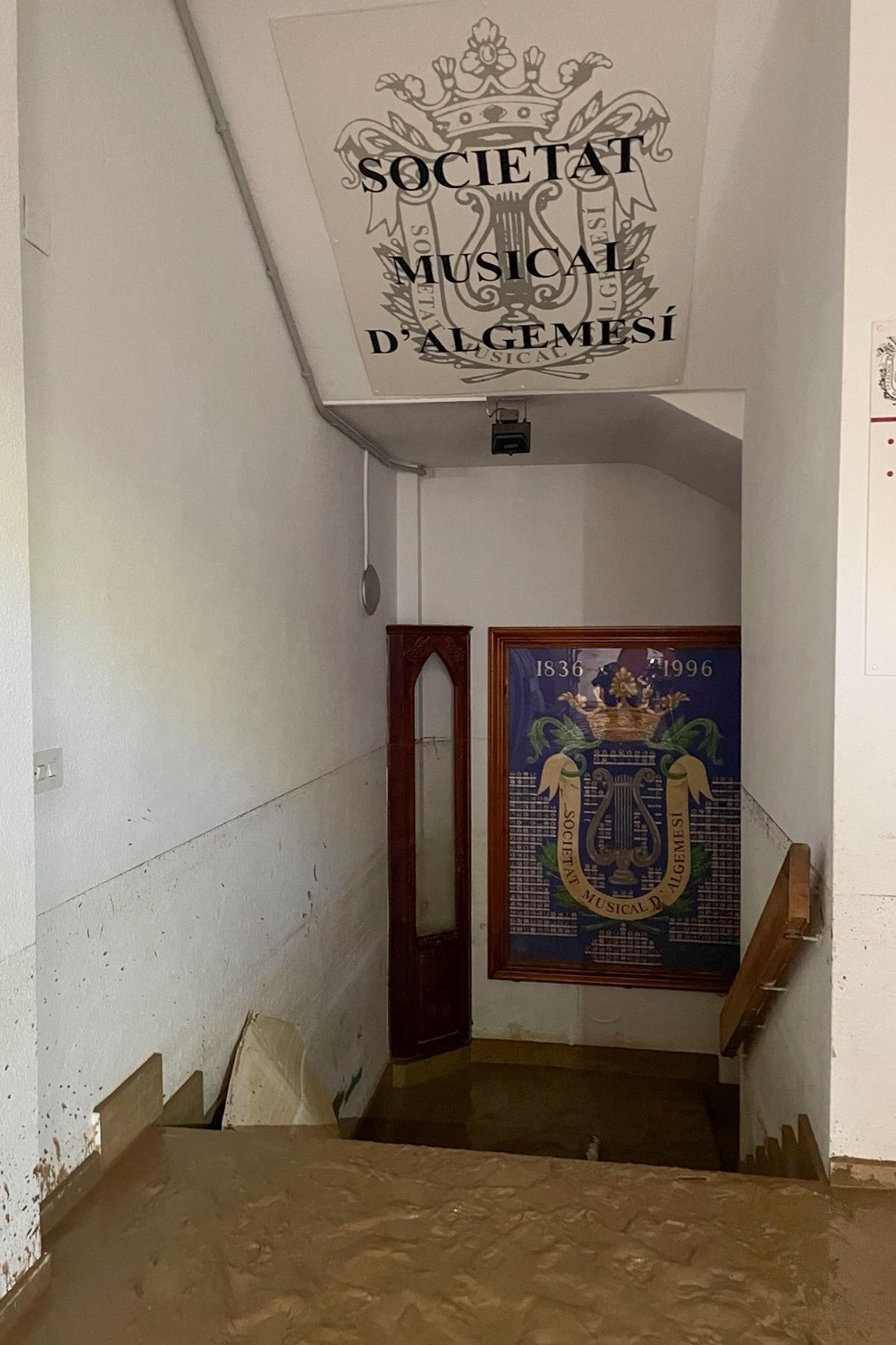 Entrada al local de la Societat Musical d'Algemesí llena de barro por la DANA.