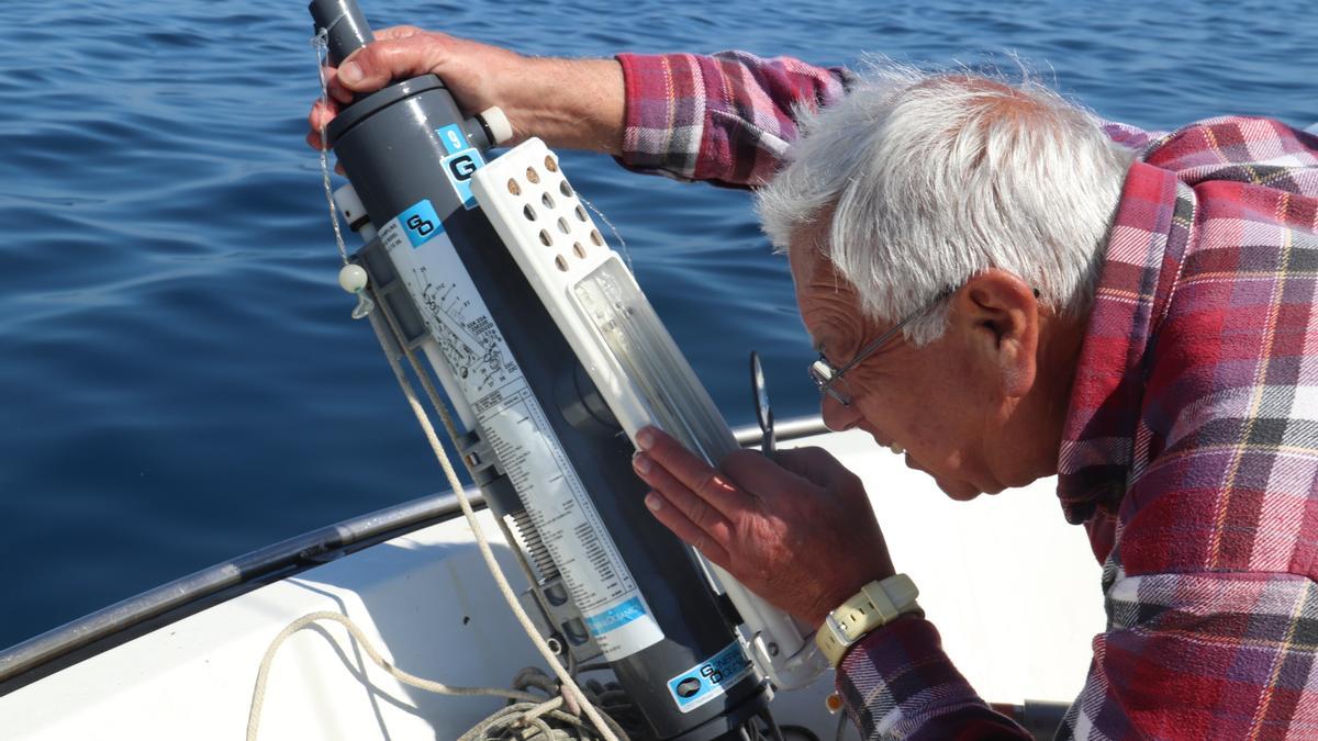 El meteoròleg Josep Pascual comprova la temperatura de l'aigua del mar que mesura amb un termòmetre de mercuri.
