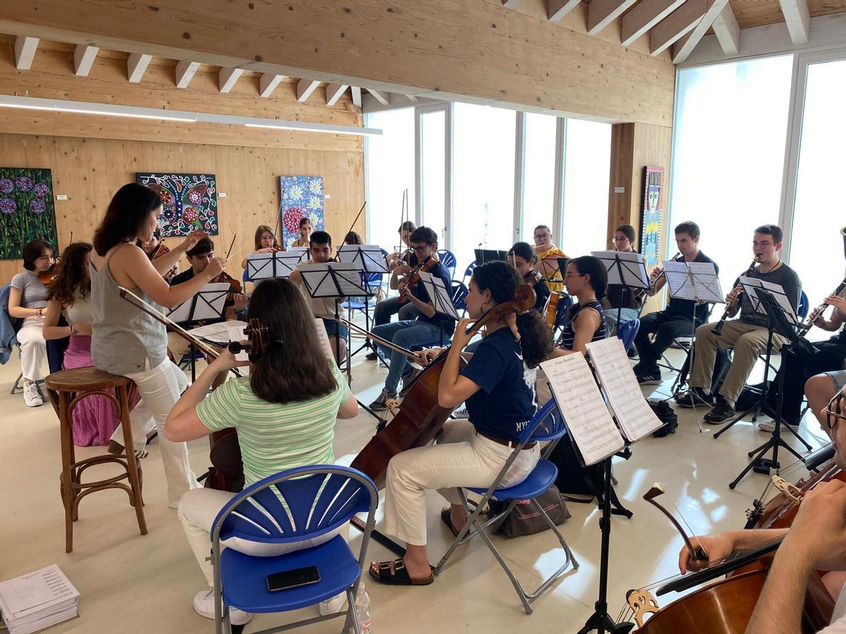 La directora y los miembros de la orquesta, durante un ensayo en Redeiras.