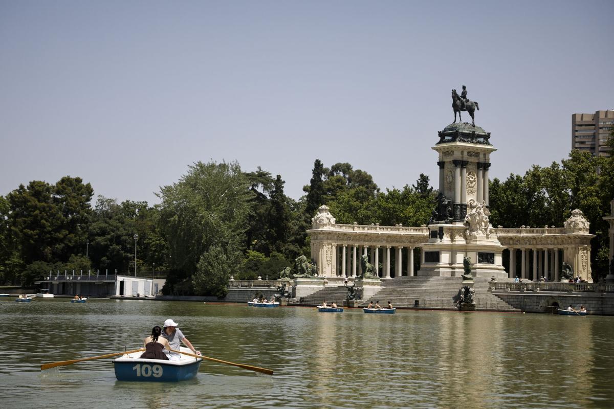 MADRID, 23/06/2026.- Varias personas montan en las barcas del estanque del Parque del Retiro, este martes. La primera ola de calor del verano llevará este martes los termómetros hasta los 44 grados en amplias zonas de España, en el día más extremo del episodio, y antes de un ligero alivio térmico previsto a partir del miércoles. EFE/ Marcos Villaoslada
