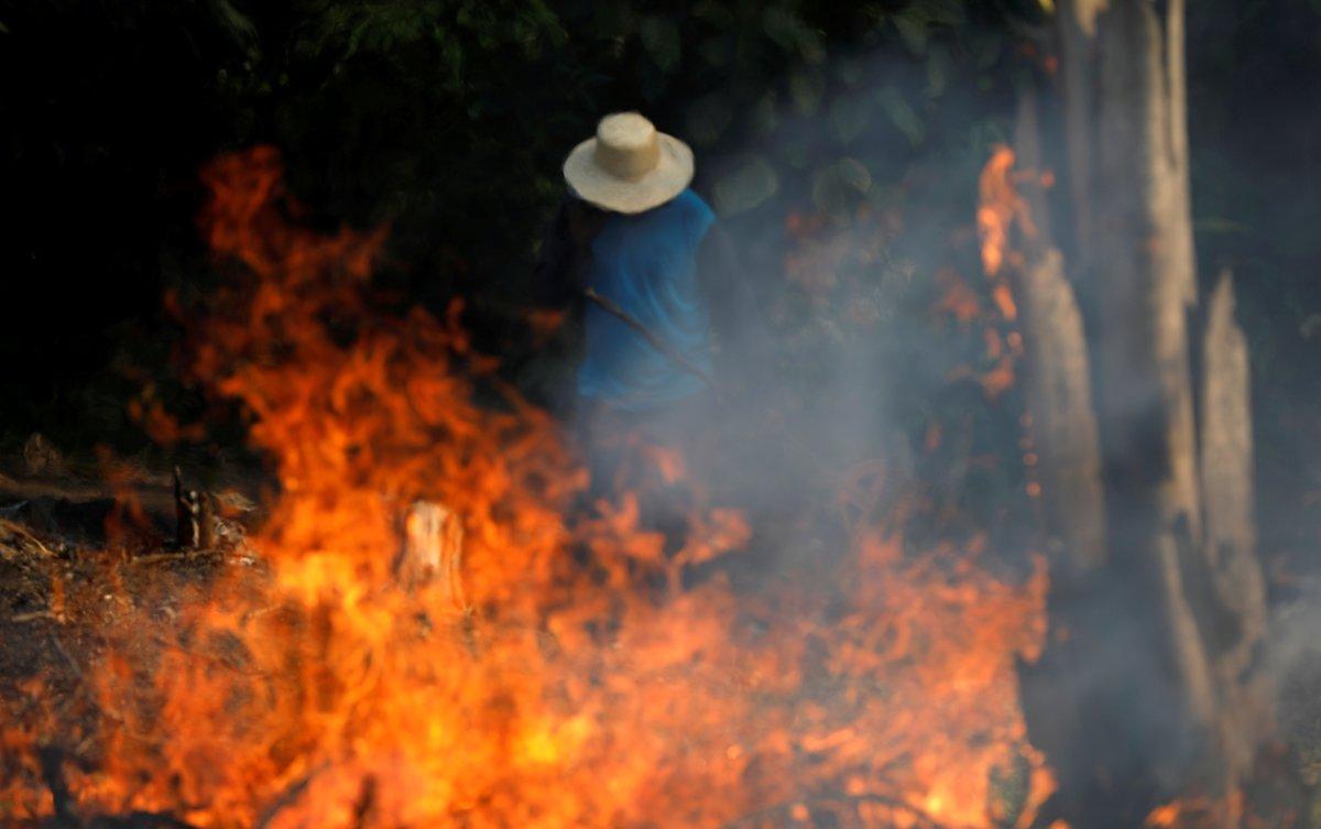 FILE PHOTO: A man works in a burning tract of Amazon jungle as it is being cleared by loggers and farmers in Iranduba, Amazonas state, Brazil August 20, 2019. REUTERS/Bruno Kelly/File Photo