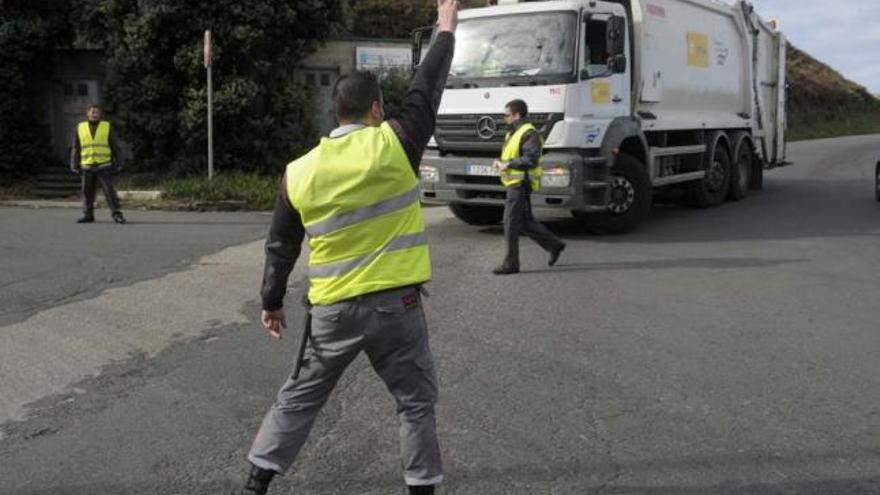 Un guardia de seguridad impide la entrada de un camión del Consorcio a Nostián. / víctor echave