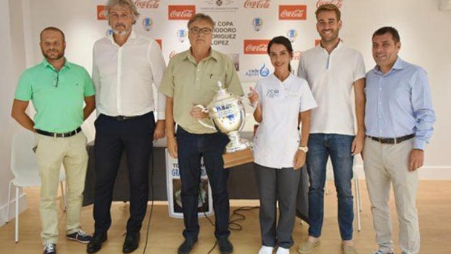 Los asistentes a la presentación posan con el trofeo.