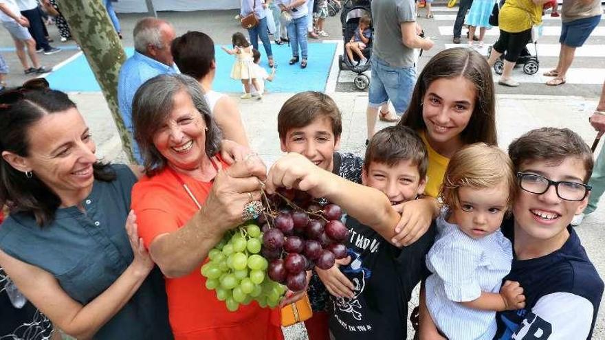 María José Giráldez, una de sus hijas y nietos, con los racimos de uvas tras ganar la subasta. // A. H.