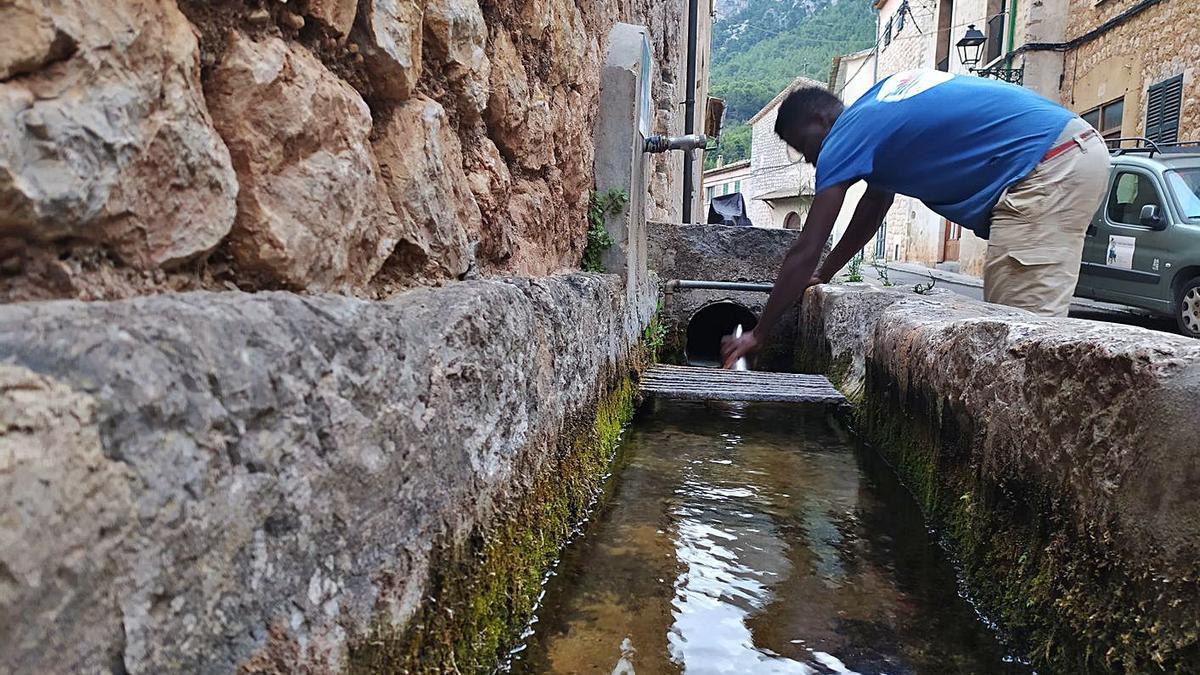 Un vecino de Sóller llena su cantimplora en el agua que emana de la font del Canyar.
