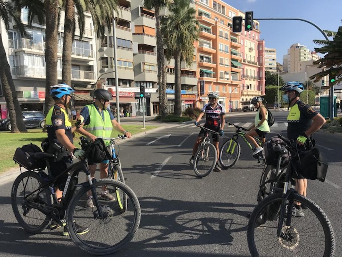 Cicloturistas charlando con una pareja de policías locales que utilizan este vehículo para su trabajo
