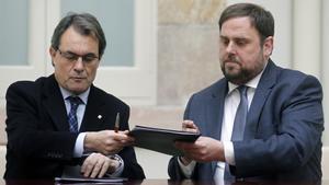 CiU leader Artur Mas and ERC leader Junqueras exchange documents of an agreed alliance at Parliament de Catalunya in Barcelona