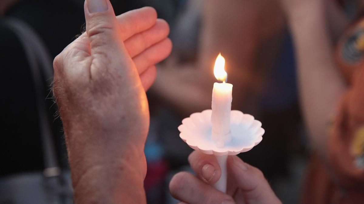 Un hombre enciende una vela por las víctimas del tiroteo en Ohio.