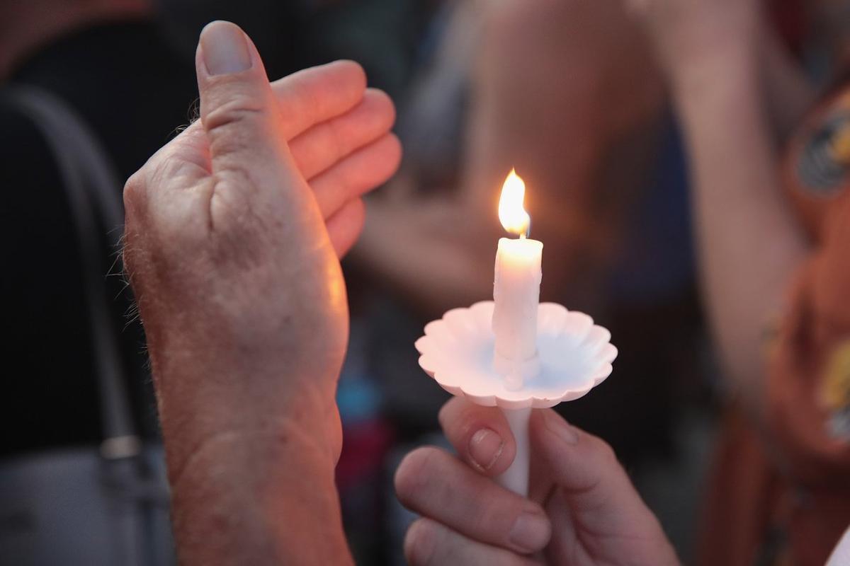 DAYTON, OHIO - AUGUST 04: Mourners attend a memorial service in the Oregon District to recognize the victims of an early-morning mass shooting in the popular nightspot on August 04, 2019 in Dayton, Ohio. At least 9 people were reported to have been killed and another 27 injured when a gunman identified as 24-year-old Connor Betts opened fire with a AR-15 style rifle. The shooting comes less than 24 hours after a gunman in Texas opened fire at a shopping mall killing at least 20 people.   Scott Olson/Getty Images/AFP