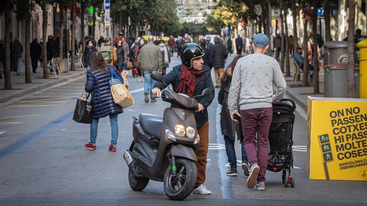Un hombre arrastra su moto en un Gran de Gràcia recuperado por los peatones