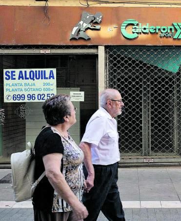 Una pareja pasea por delante de uno de los locales cerrados. | A. B.