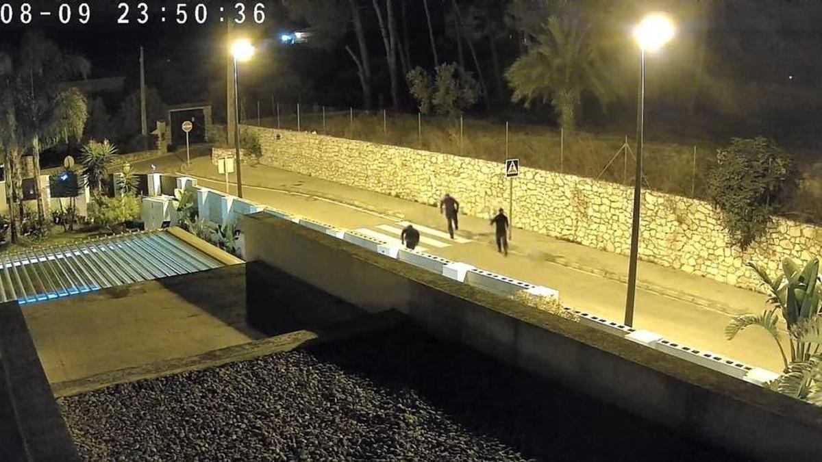 Imagen de los tres individuos vestidos con ropa oscura delante de un chalet de Bixquert.