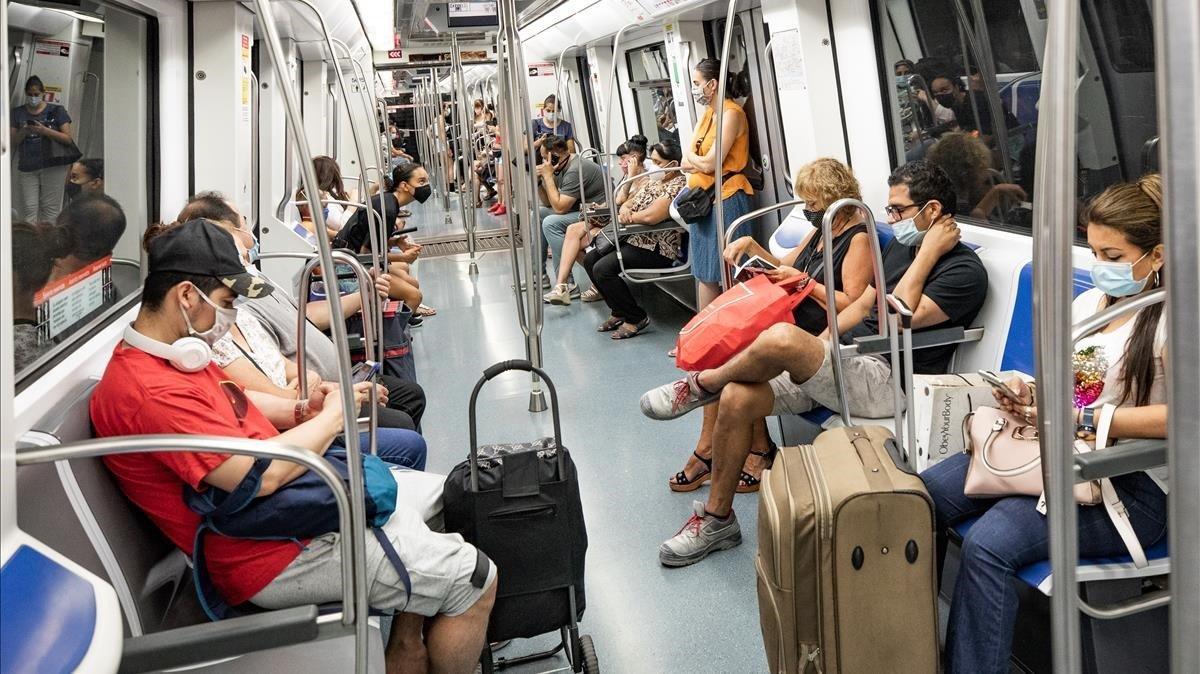 Pasajeros con mascarilla en la línea 5, este miércoles entre Diagonal y Sants.