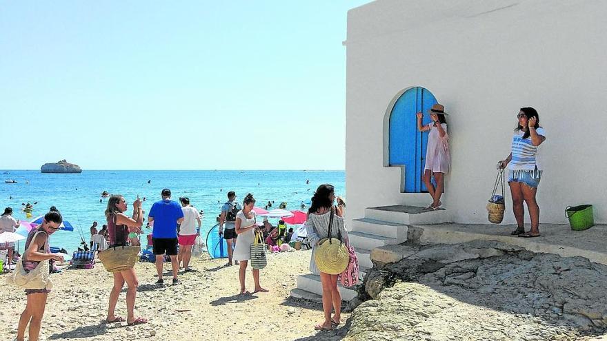 La cala de la Barraca está de moda. Los bañistas acuden con la idea de disfrutar de una playa de gran belleza y hacerse una foto en una de sus casitas tradicionales de pescadores. Enjalbegadas de blanco y con las puertas y ventanas pintadas de azul, estas casas triunfan en las redes sociales.